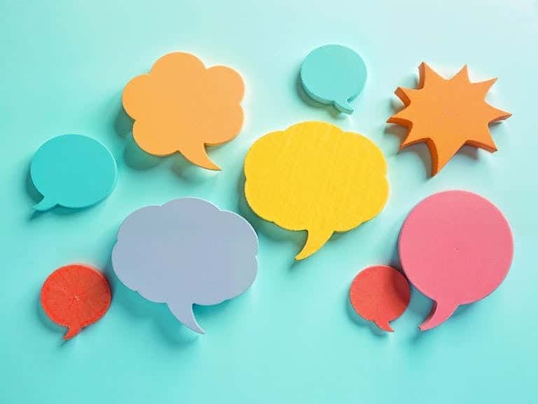 Vibrant paper cut speech bubbles on a turquoise background, perfect for communication themes.