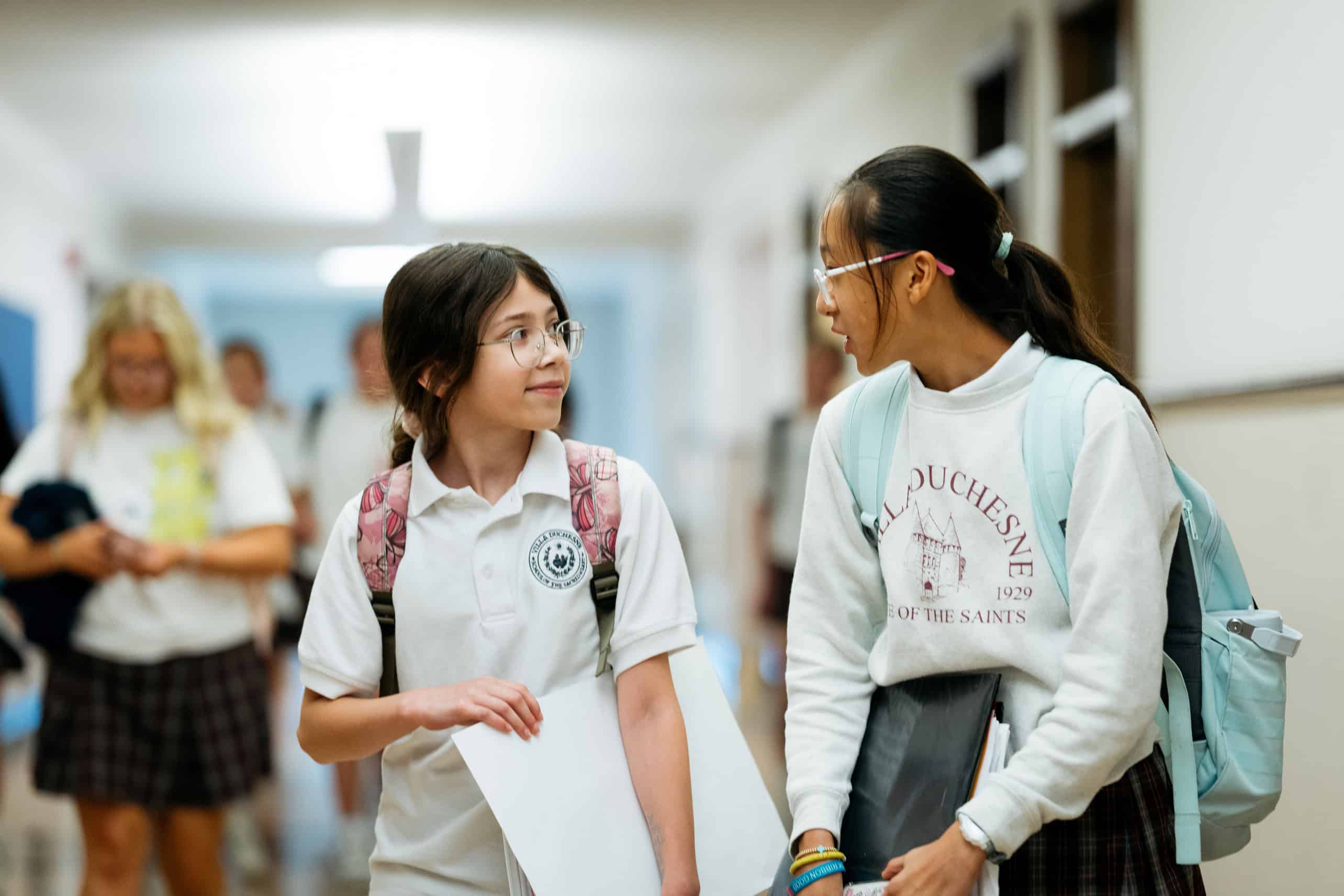 Two Villa Duchesne students talking in a school hallway